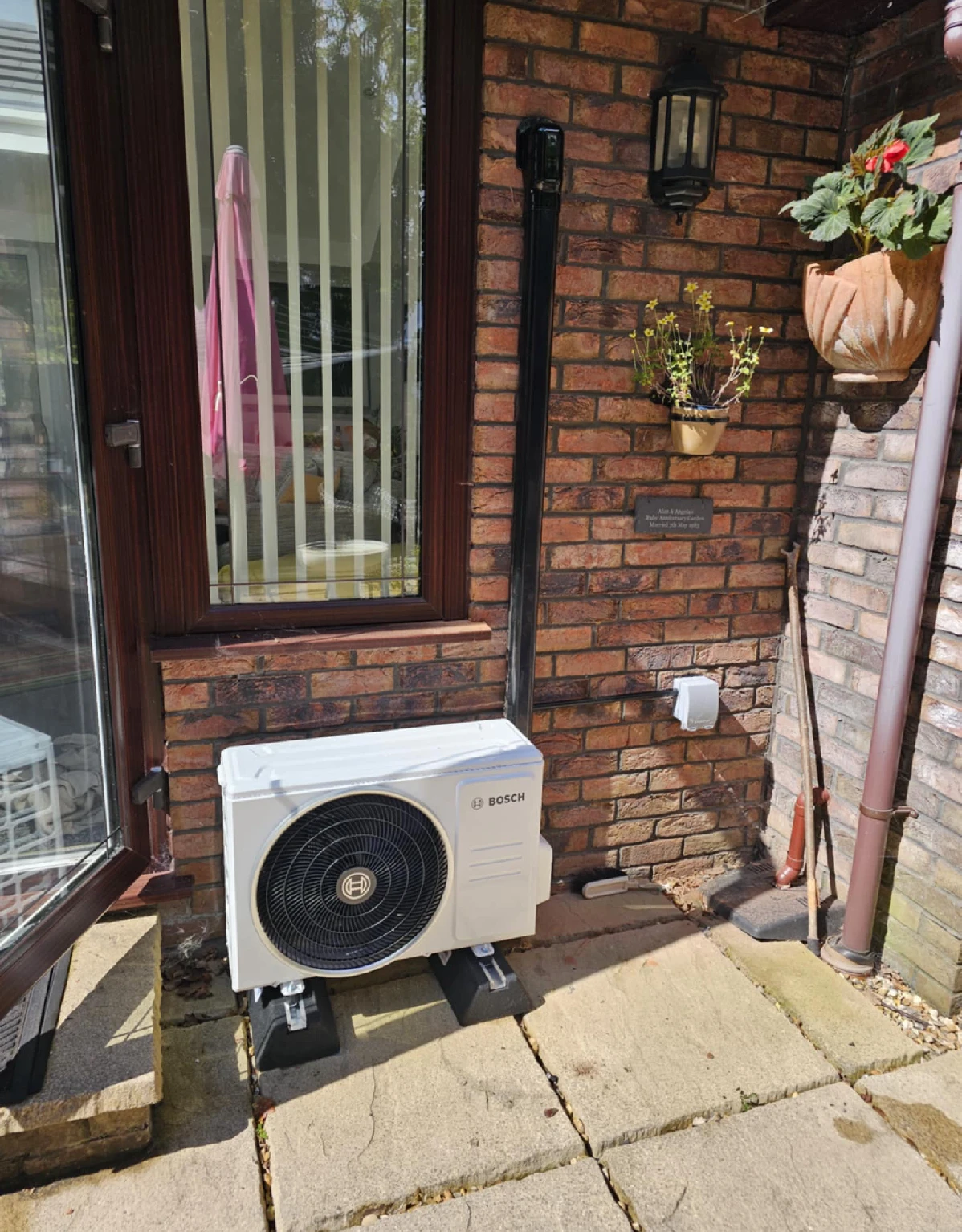 Bosch outdoor unit on a patio beside a conservatory